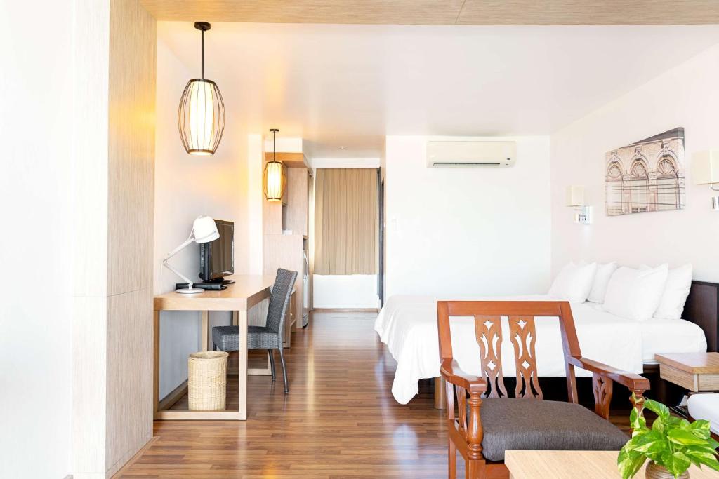 Mūsdienīga viesnīcas numura interjers ar koka grīdu, ērtu gultu, rakstāmgaldu un televizoru. Telpā ir gaismas ķermeņi un augi, kas piešķir siltumu un mājīgumu.