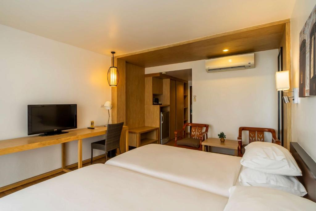 Mūsdienīgs viesnīcas numurs ar divām atsevišķām gultām, TV, darba galdu un ērtu atpūtas zonu. Interjers ir gaišs un elegants, radot patīkamu atmosfēru.