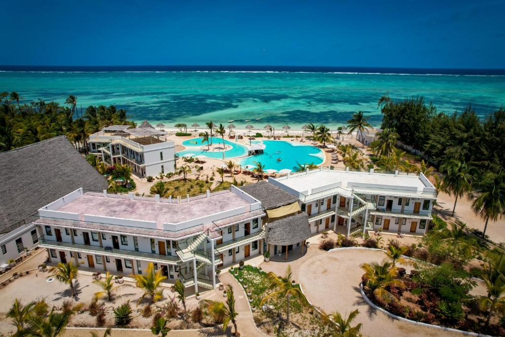 The One Resort Zanzibar piekrastē ar baseinu un palmu kokiem.