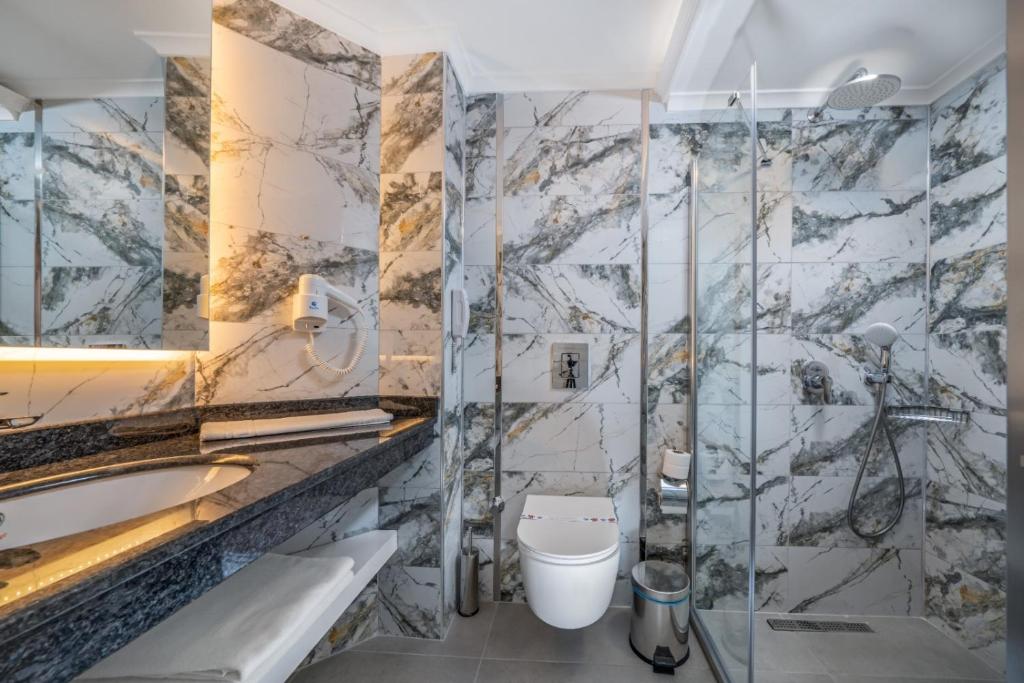 Mūsdienīgs vannas istabas interjers Aria Resort & Spa Hotel ar akmens apdari.