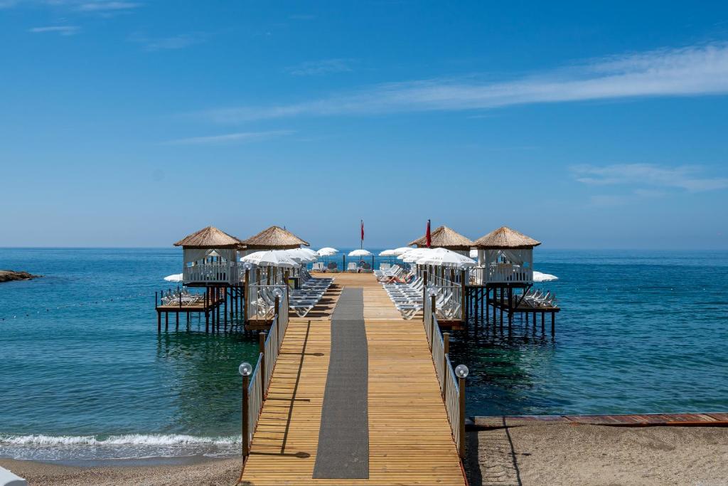 Koka piestātne pie Aria Resort & Spa Hotel ar pludmales gultām un saulessargiem.