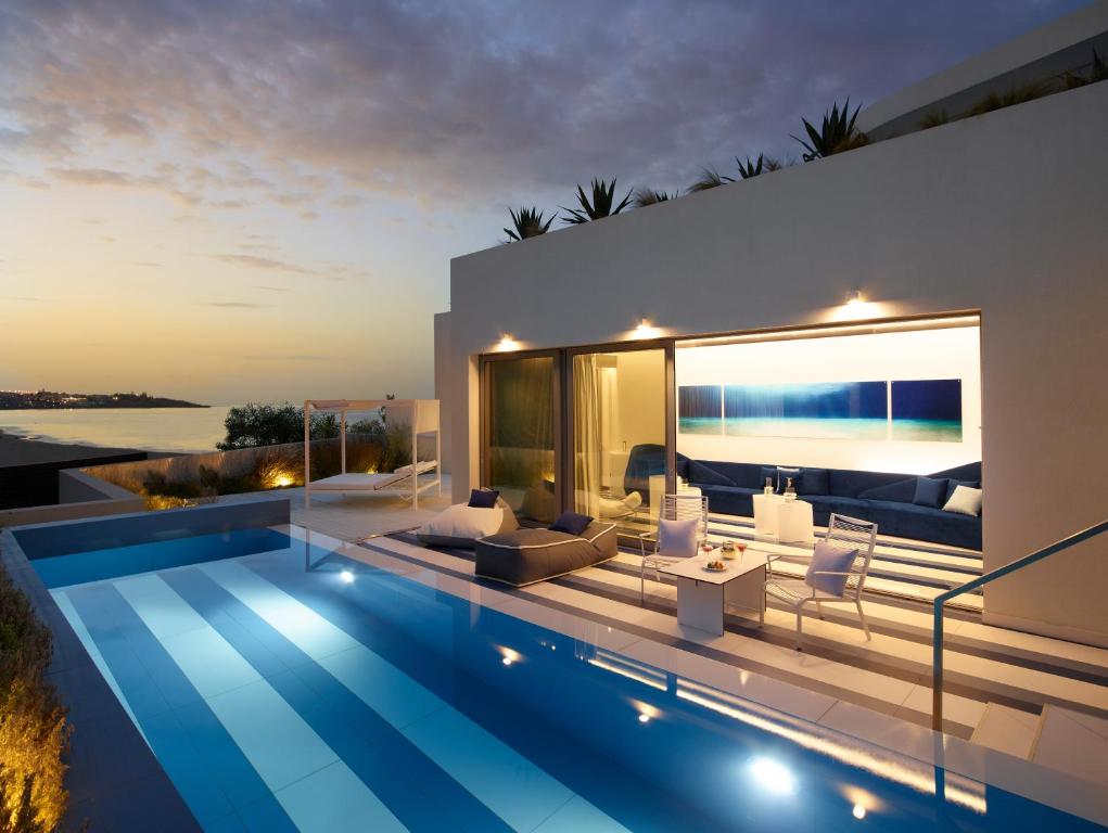 Paviljons ar baseinu un terasi pie I-Resort Beach Hotel & Spa saulrieta gaismā. panoramic view with beach and pools