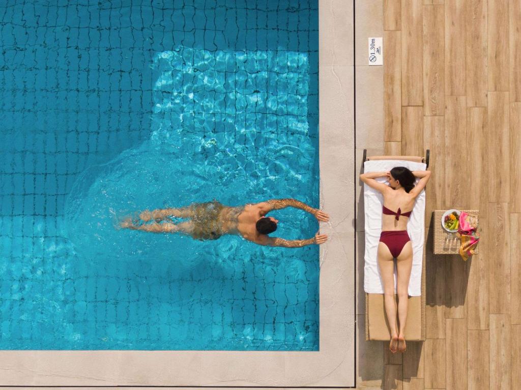 Peldbaseins ar viesi, kas peld un atpūšas pie Creta Maris Resort