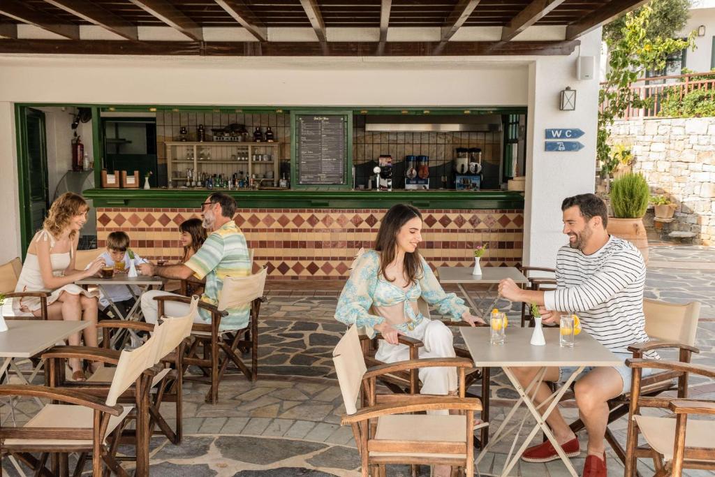 Ģimenes laiks pie Creta Maris Resort restorāna, cilvēki ar dzērieniem.
