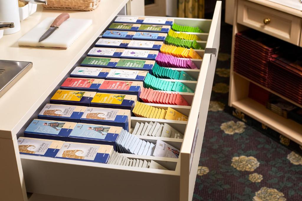 Kāpostu atvilktne ar krāsainām tējas paciņām, kārtīgi sakārtota un sakārtota, piedāvājot dažādas garšas un veidus. Ideāla vieta tējas cienītājiem.