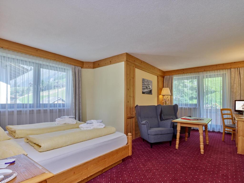 Mūsdienīgs viesnīcas numurs ar divām gultām, ērtu krēslu un rakstāmgaldu, kurš piedāvā skatu uz ainavu caur lieliem logiem. Siltas krāsas un koka elementi rada mājīgu atmosfēru.