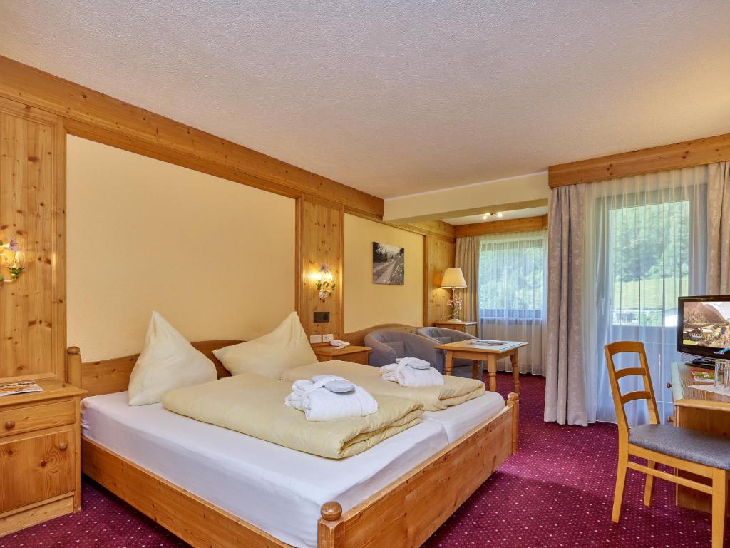 Mūsdienīgs viesnīcas numurs ar divguļamo gultu, ērtām mēbelēm un logiem, caur kuriem ieplūst dabisks apgaismojums. Interjers ir veidots ar koka elementiem un siltām krāsām, radot mājīgu atmosfēru.