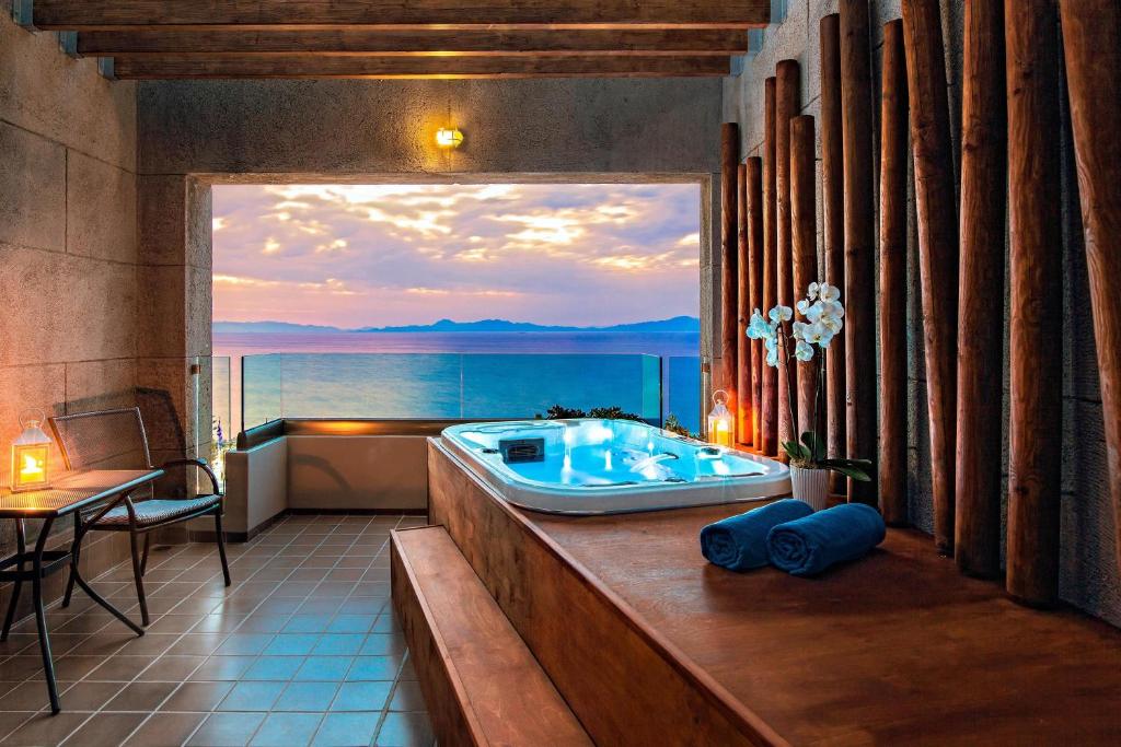 Relaksējoša terase ar privātu džakuzi Sheraton Rhodes Resort piekrastē.