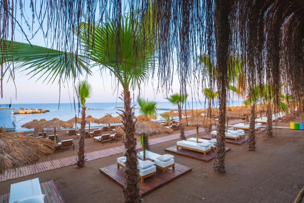 Rubi Platinum Sign pludmales zona ar palmām un atpūtas gultām piekrastē