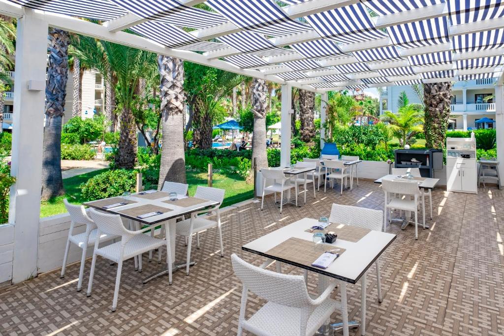 Utopia Resort & Residence terase ar galdiem un palmām