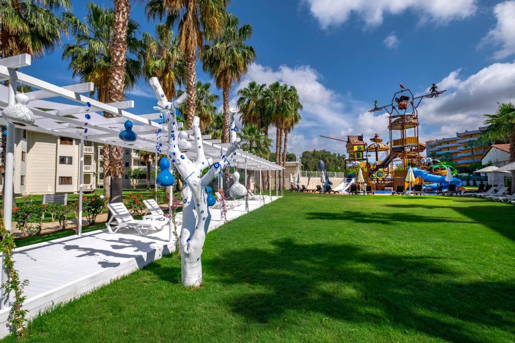 Utopia Resort & Residence dārzs ar rotaļu laukumu un palmām