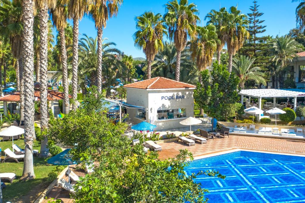 Utopia Resort & Residence baseins ar bāru un palmu ainavu