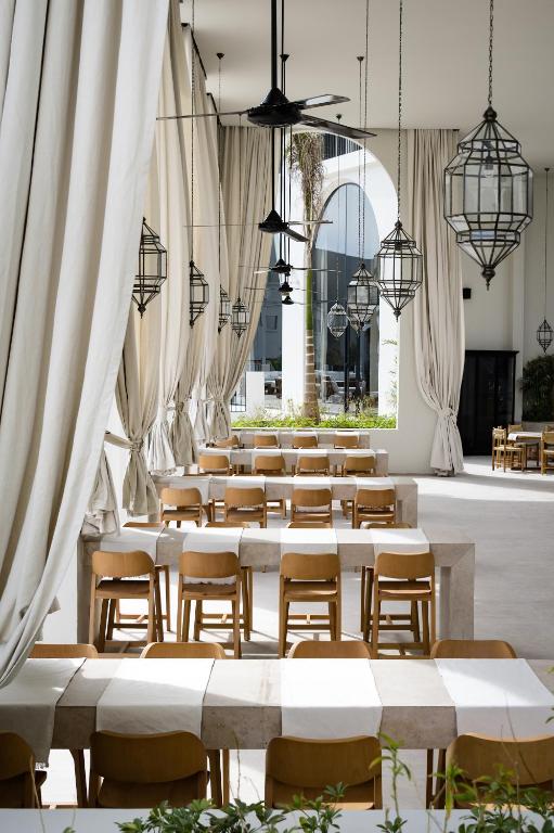 Serry Beach Resort restorāna interjers ar elegantām lampām un koka krēsliem.