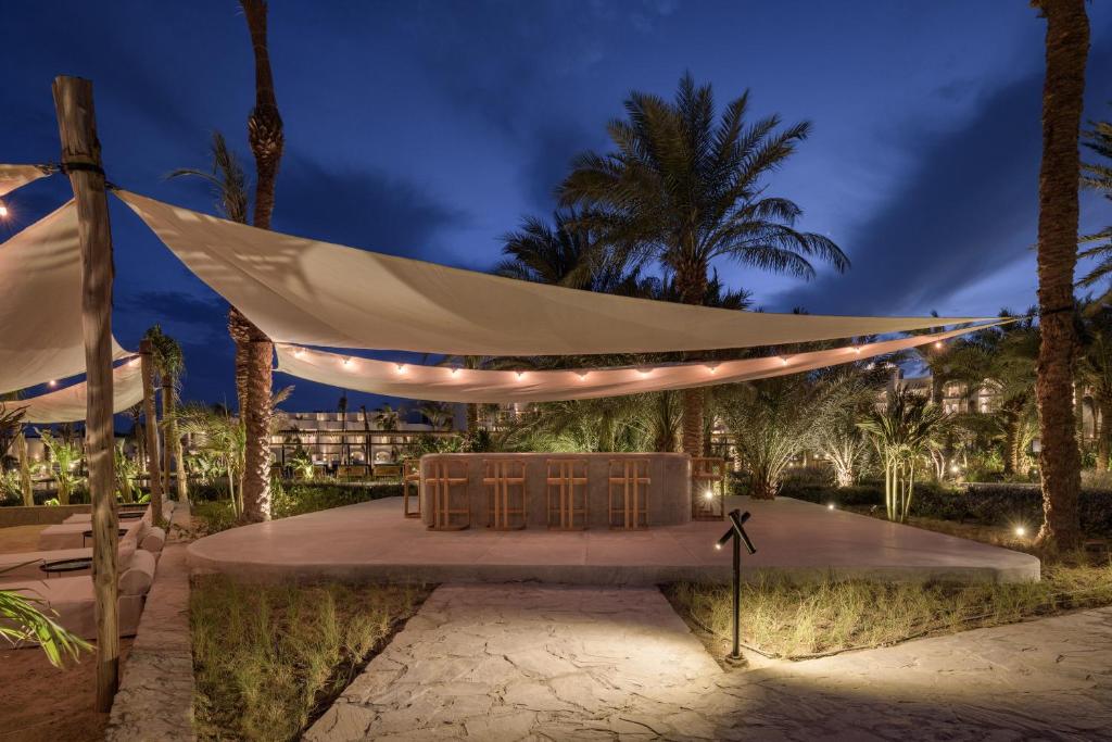 Serry Beach Resort āra bārs ar apgaismojumu piekrastē naktī.