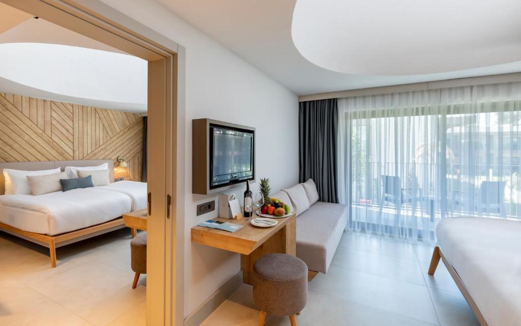 Mūsdienīgs numurs viesnīcā Paloma Orenda ar koka akcentiem un balkonu.