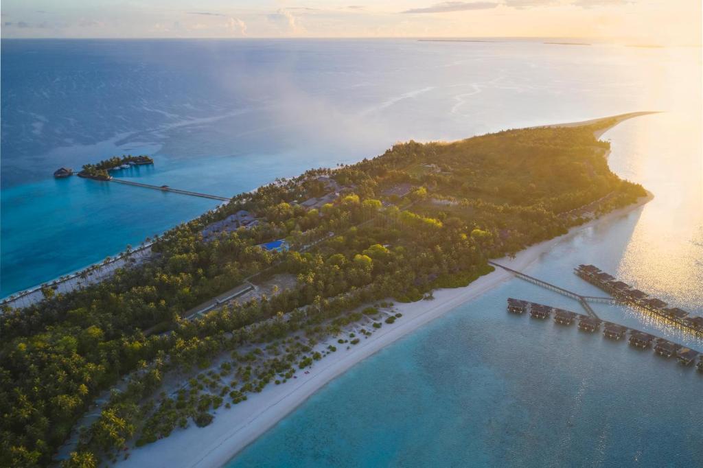 Tropu sala ar pludmali un luksusa viesnīcām, kas atrodas tuvumā skaidrajiem zilajiem ūdeņiem. Gaismas staru ietekme rada mierīgu un idillisku atmosfēru.