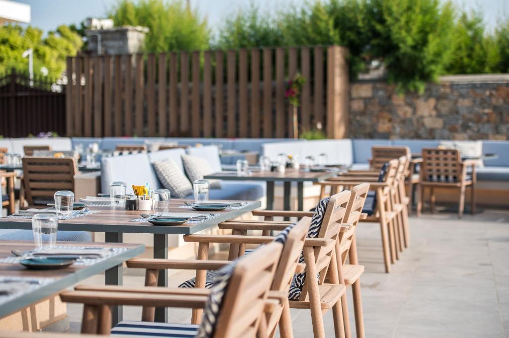Āra restorāns Creta Maris Resort ar elegantām mēbelēm un skaistu apzaļumošanu.