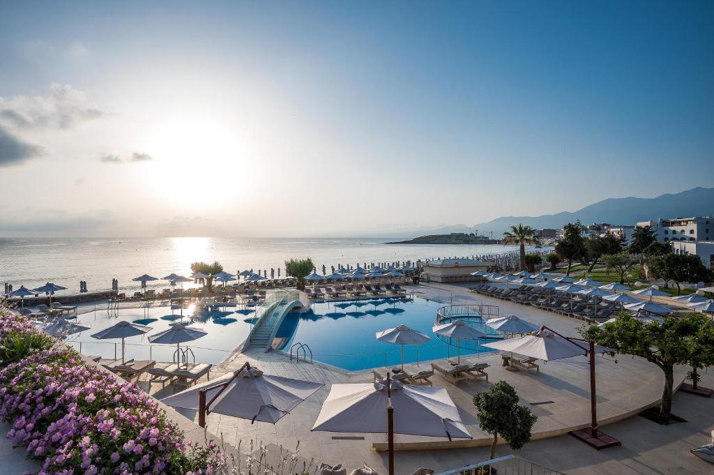 Creta Maris Resort baseins ar skatu uz saulrietu piekrastē