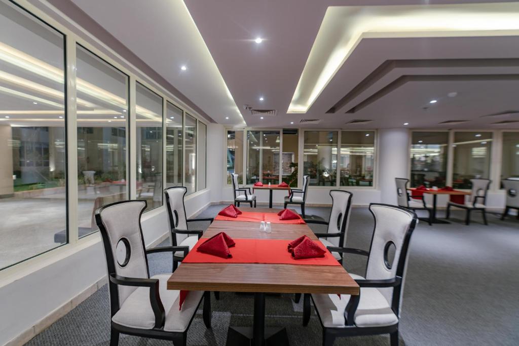 Mūsdienīgs restorāns ar elegantām galdiem un sarkanām salvetēm Seven Seas Jolie Bay