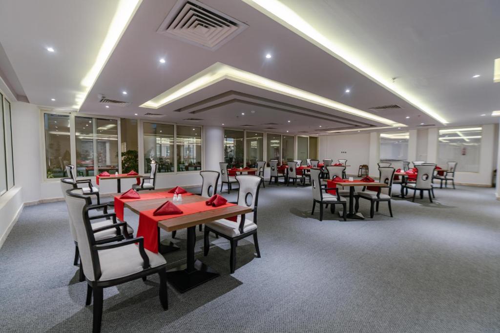 Mūsdienīgs restorāns Seven Seas Jolie Bay ar elegantām mēbelēm un sarkaniem galdautiem.