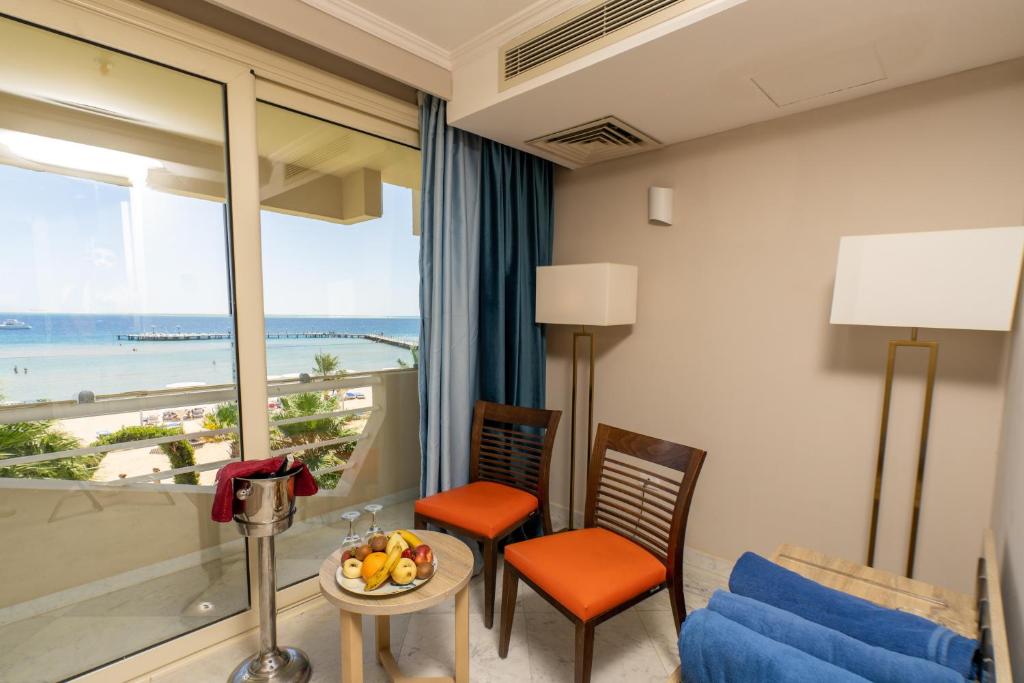 Skats uz jūru no Seven Seas Jolie Bay numura ar krēsliem un augļiem.