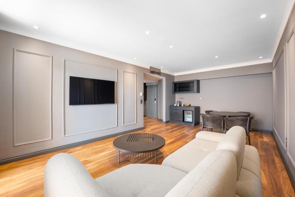 Mūsdienīgs viesnīcas numurs ar viesistabu un televizoru Adora Hotel & Resort