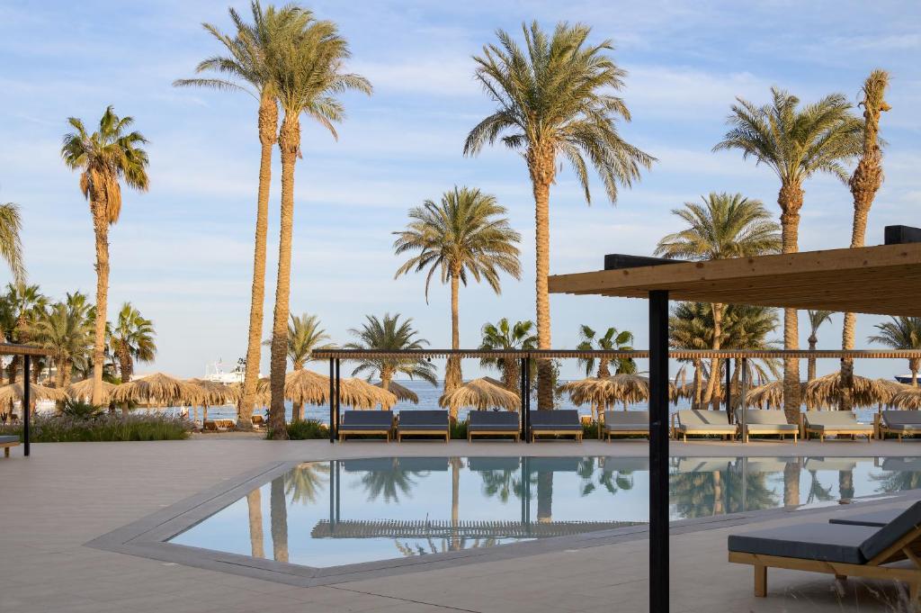 Serry Beach Resort baseins ar palmām un piekrasti