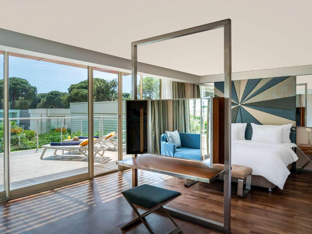 Mūsdienīgs numurs Rixos Premium Belek ar terasi un dārza skatu.