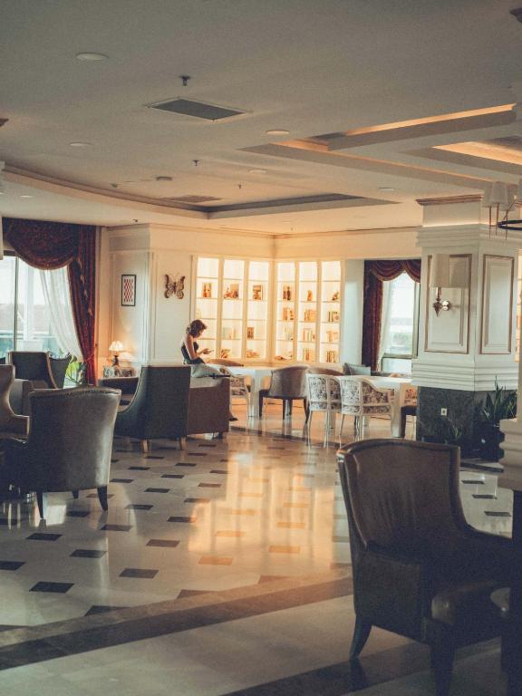 Eleganta atpūtas zona Castival Hotel ar grāmatām un mīkstiem krēsliem.