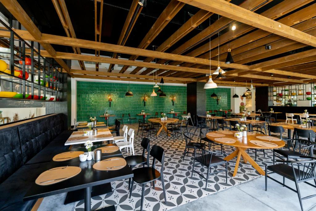 Mūsdienīgs restorāns ar koka griestiem un zaļām flīzēm DoubleTree by Hilton Antalya-Kemer.