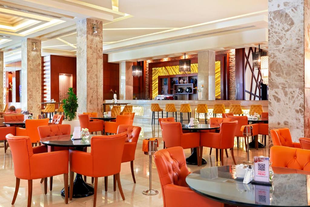 Moderns restorāns hotelī Albatros White Beach Resort ar oranžām krēslām.