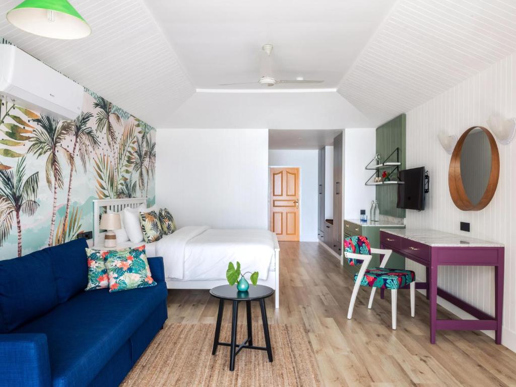 Mūsdienīgs viesnīcas numurs ar tropisku sienu apdari, stilīgu dīvānu un ērtu darba galdu. Gaismas un krāsas rada relaksējošu atmosfēru.