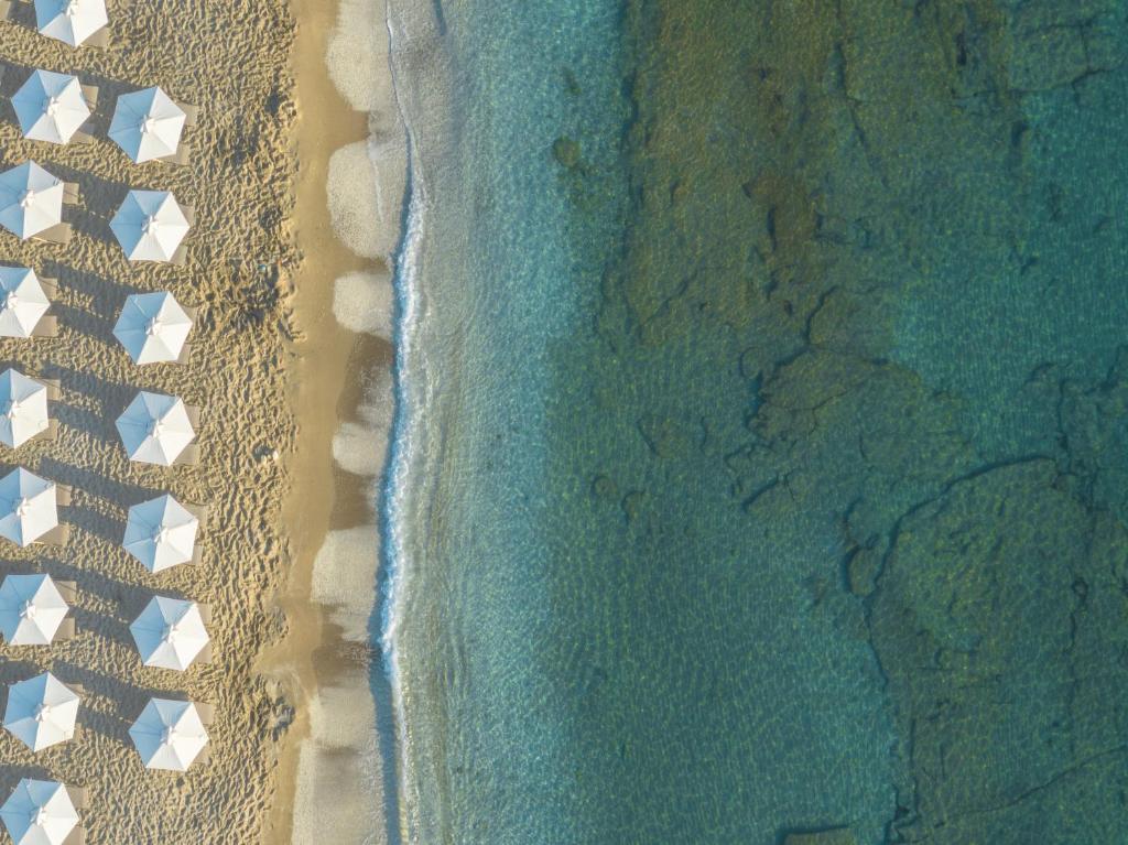 Pārskats uz pludmali ar baltiem saulessargiem pie Creta Maris Resort