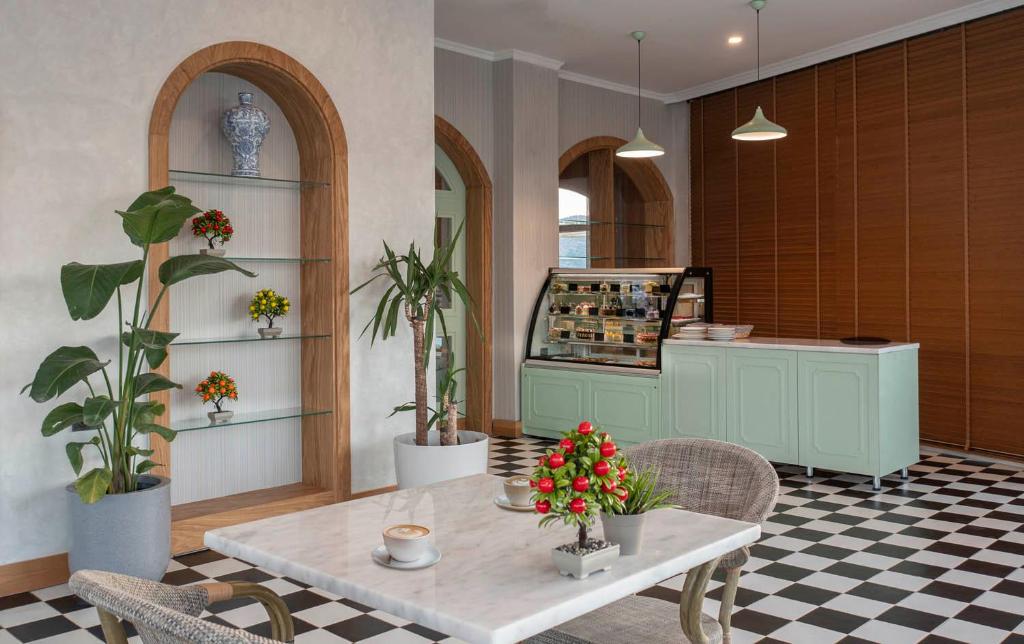 Elegants kafijas stūrītis Holiday Inn Resort Bodrum ar zaļām augu dekorācijām.