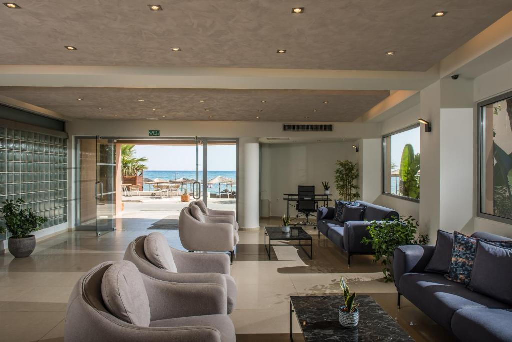 Mūsdienīgs viesnīcas vestibilis ar ērtām mēbelēm un skatu uz jūru. Gaismas interjers un zaļumi rada relaksējošu atmosfēru.