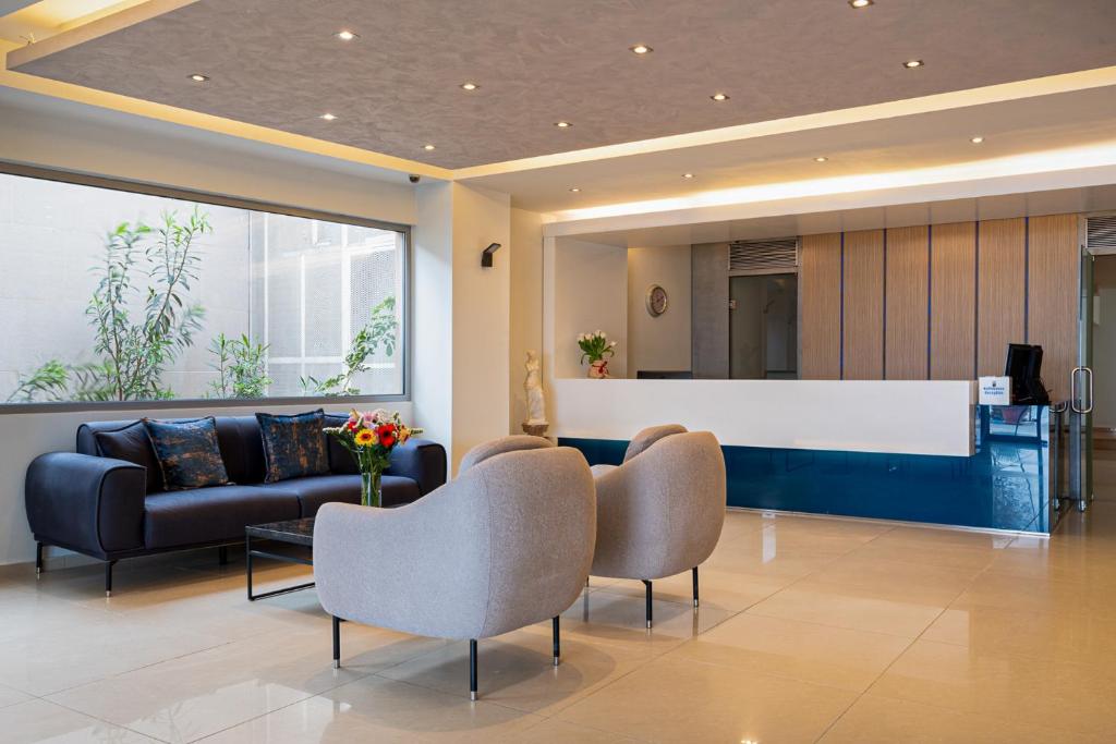 Mūsdienīgs viesnīcas reģistratūras interjers ar dīvānu, krēsliem un ziedu kompozīciju uz galda. Labi apgaismots un gaumīgi iekārtots telpas dizains.
