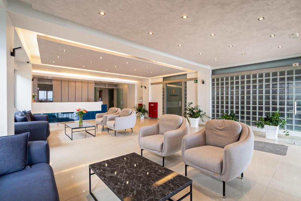 Mūsdienīgs un elegants viesnīcas uzgaidāmā telpa ar ērtiem krēsliem, tumšas marmora galdu un dekoratīvām augu kompozīcijām. Gaismas apgaismojums rada siltu un viesmīlīgu atmosfēru.