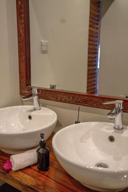 Divi izlietnes un spogulis vannasistabā, Michamvi Sunset Bay.