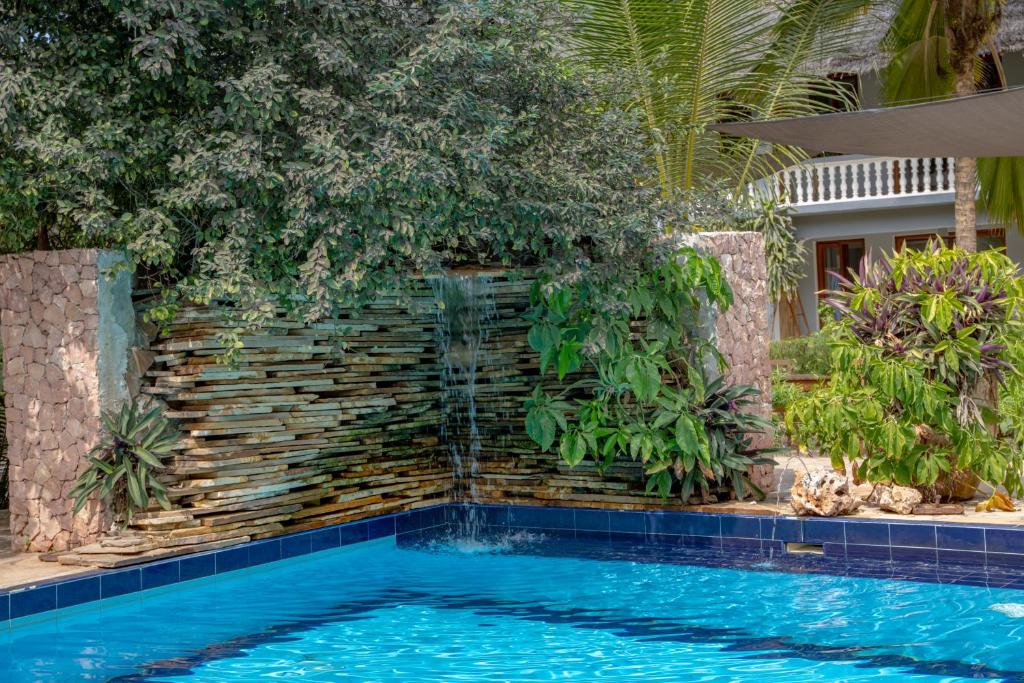 Michamvi Sunset Bay baseins ar ūdenskritumu un tropu augiem.