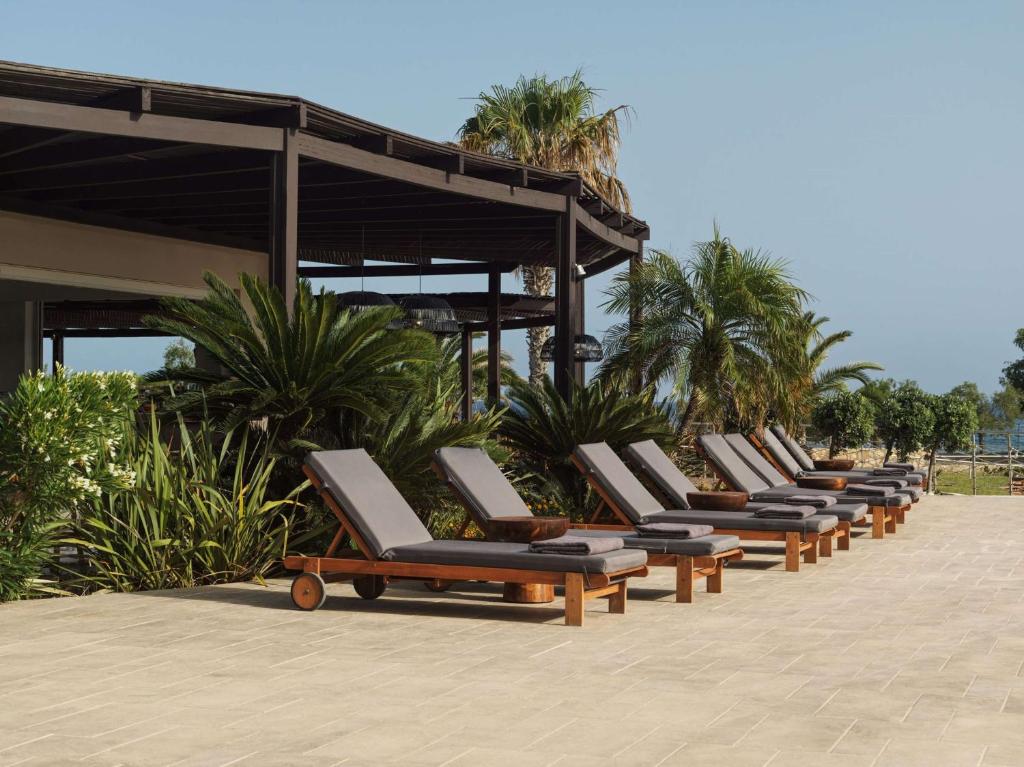 Atpūtas krēslu rinda pie Lindian Village Beach Resort Rhodes, Curio Collection by Hilton