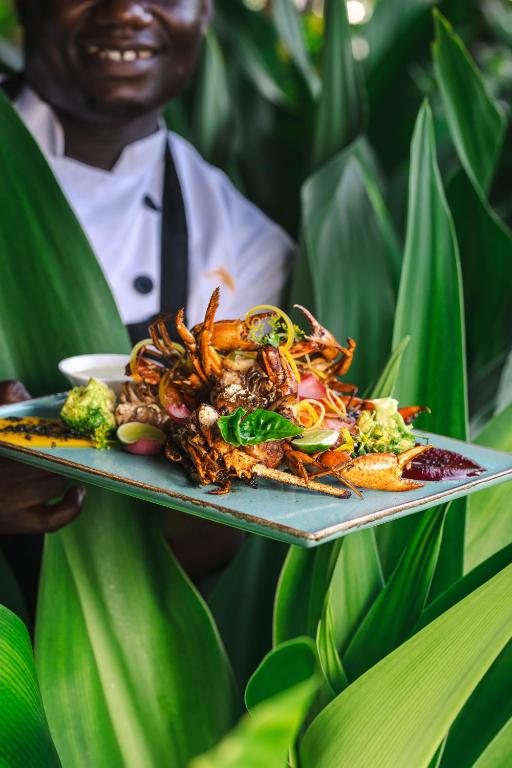 Zanzibar Queen restorāna jūras veltes ēdiens ar zaļumiem.