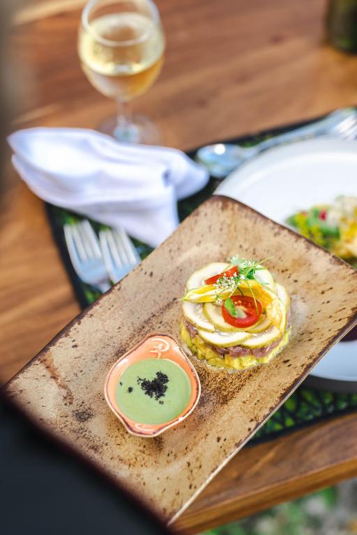 Zanzibar Queen restorāna izsmalcināts ēdiens ar glāzi baltvīna.