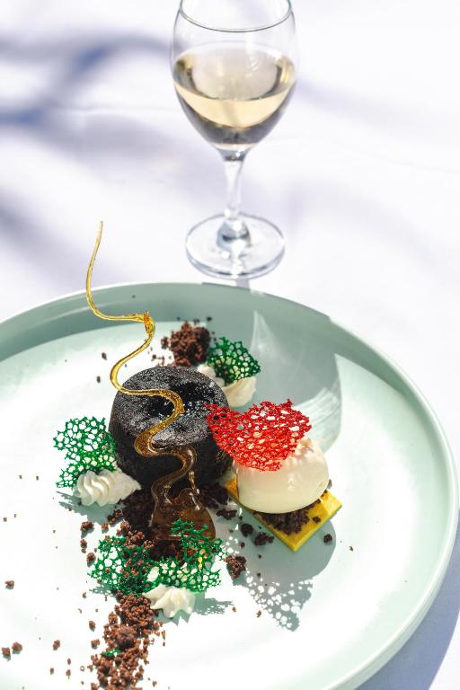 Izsmalcināts deserts ar vīna glāzi restorānā Zanzibar Queen.