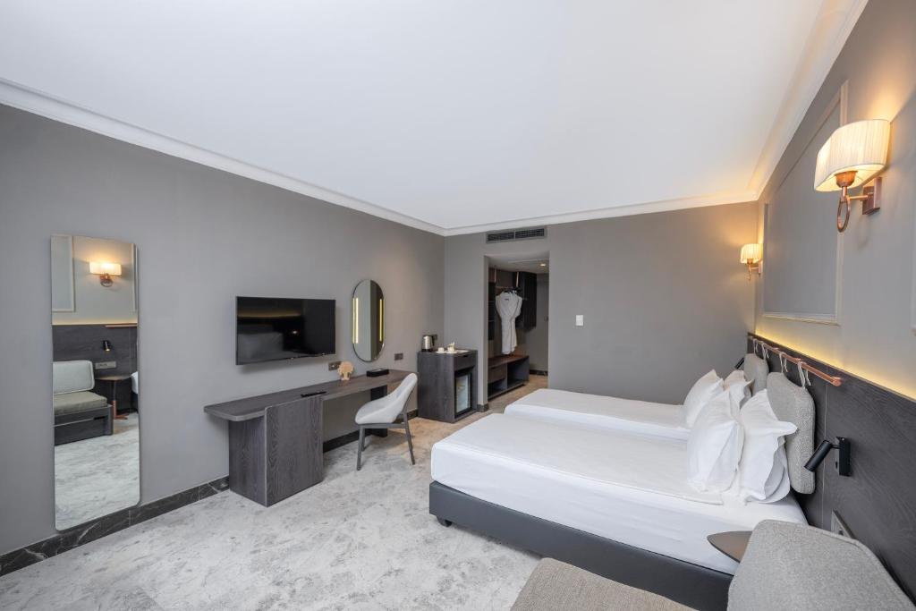 Moderns un stilīgs numurs Adora Hotel & Resort ar divām gultām un televizoru.