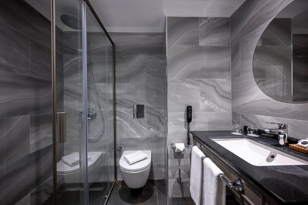 Mūsdienīgs vannas istabas interjers Adora Hotel & Resort ar dušu un elegantu apdari.