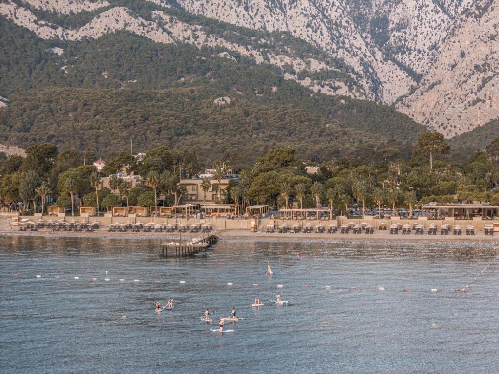 Balmy Beach Resort Kemer piekrastē ar aktivitātēm ūdenī un kalnu fonu.