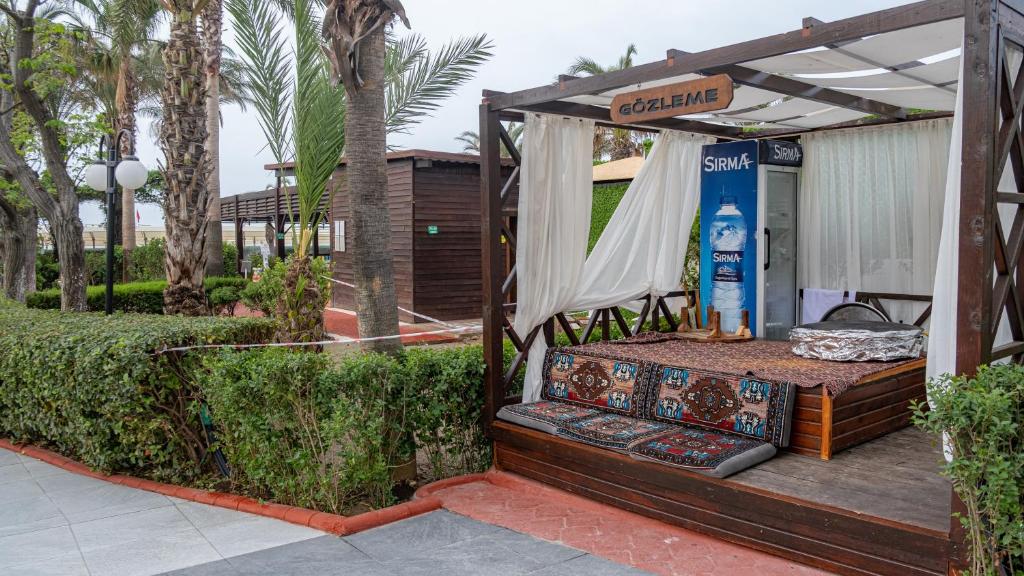 Aydinbey Famous Resort Gözleme stends ar dīvāniem un palmiem piekrastē