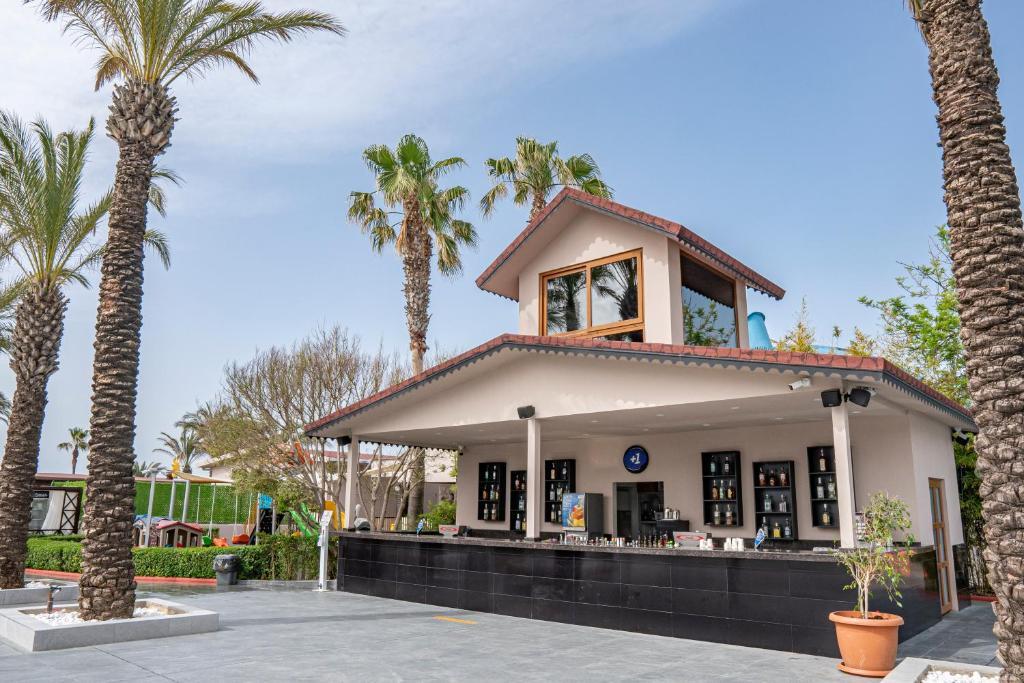 Aydinbey Famous Resort bārs ar palmu kokiem apkārt.
