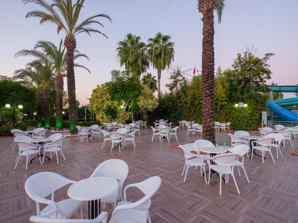 Aydinbey Famous Resort āra terase ar palmām un galdiem