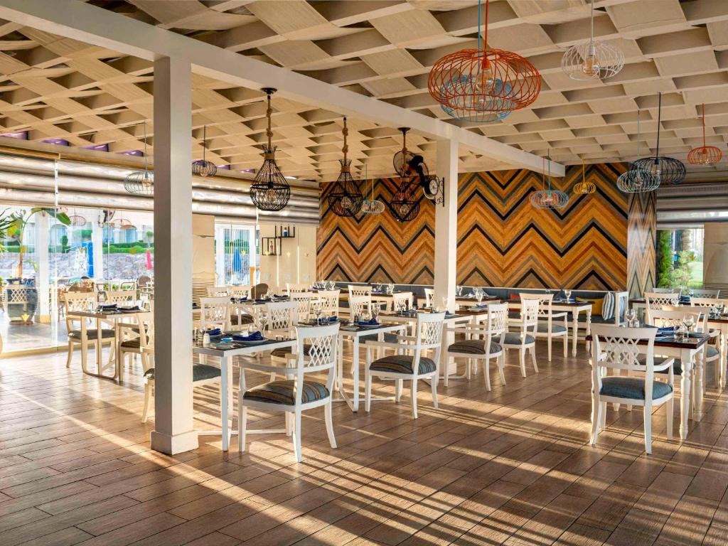 Mūsdienīgs restorāns Rixos Sharm El Sheikh ar plašu ēdamzāli un modernu dizainu.